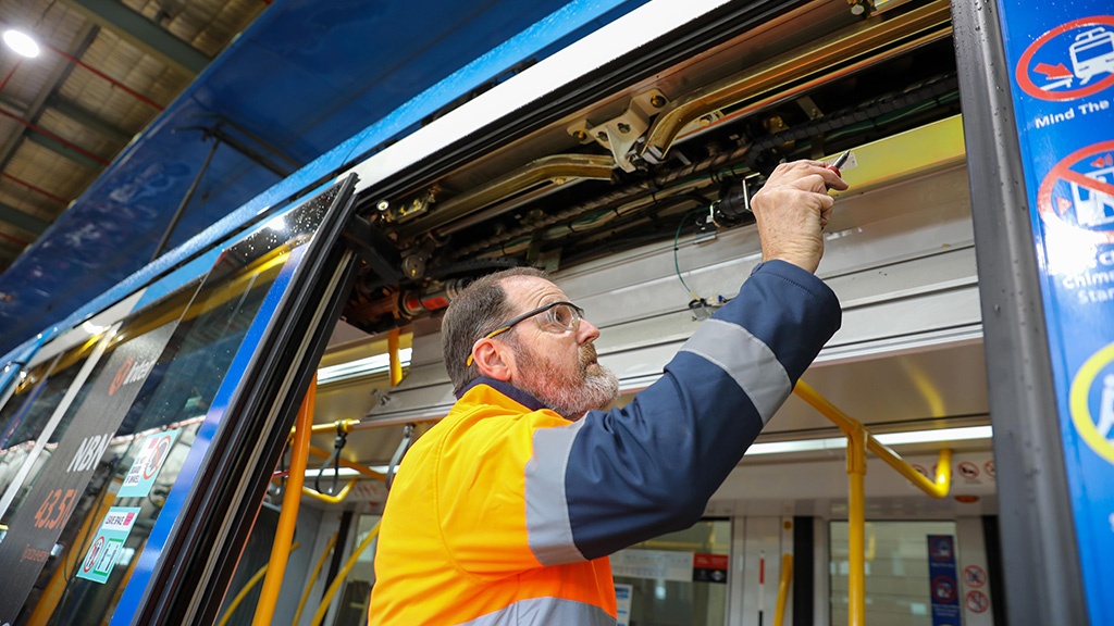 A maintenace team member checking the operation of the doors on a Citadis tram.